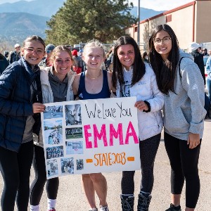 Girls holding poster that says, "We love you Emma! State 2023"